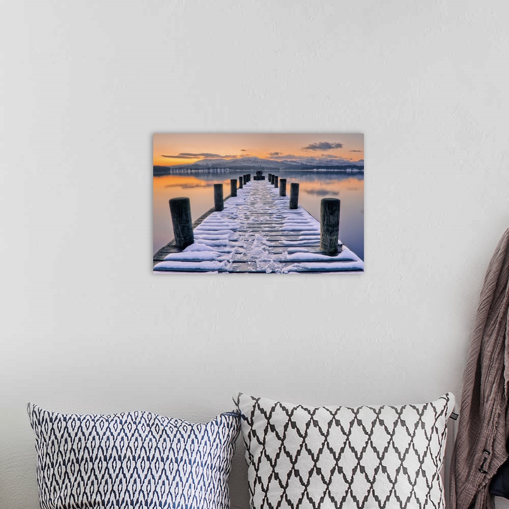 A bohemian room featuring Snow covered jetty leading to beautiful sunset scene.