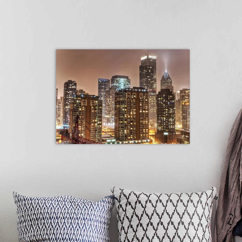 A bohemian room featuring A photograph taken of the Chicago skyline at night with the buildings illuminated and snow beginn...