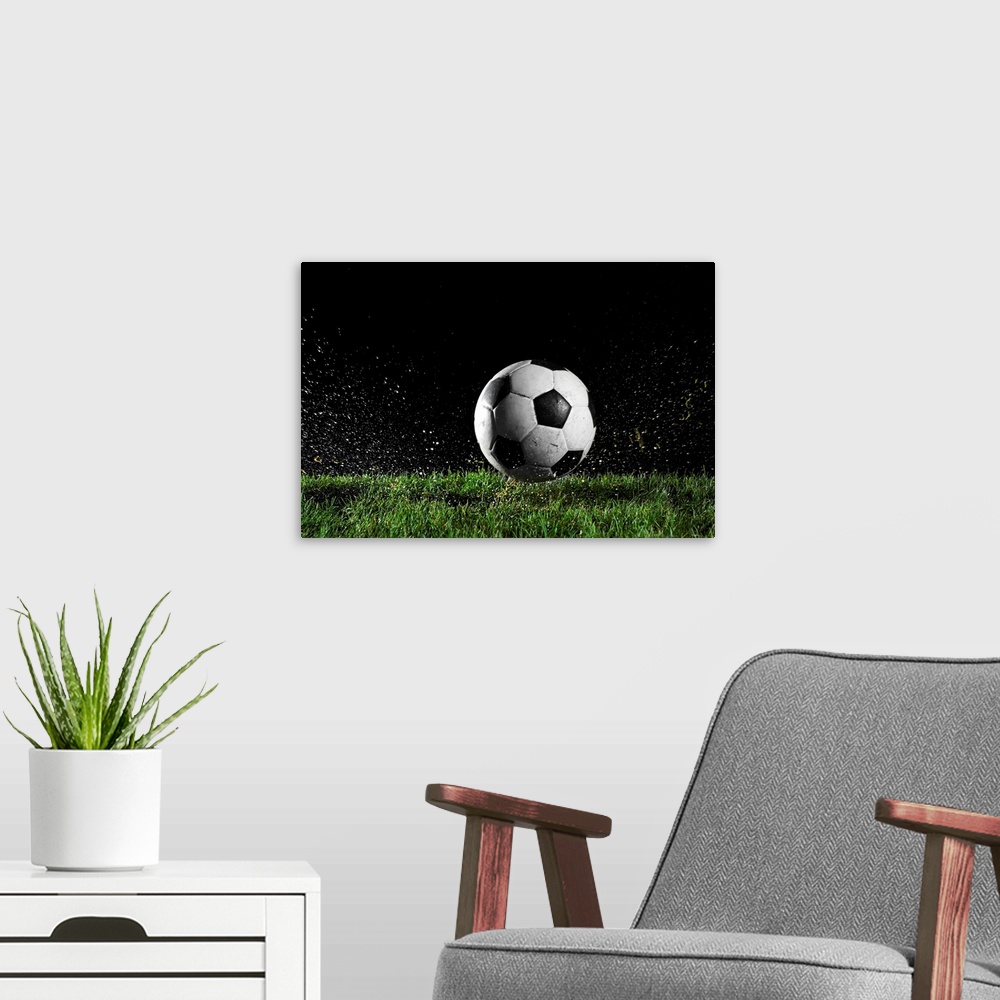 A modern room featuring Photographic print of a soccer ball moving across wet grass from a kick.