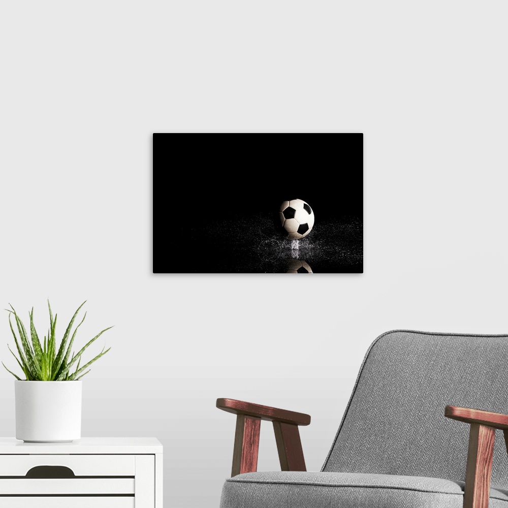 A modern room featuring Soccer ball on black reflective surface