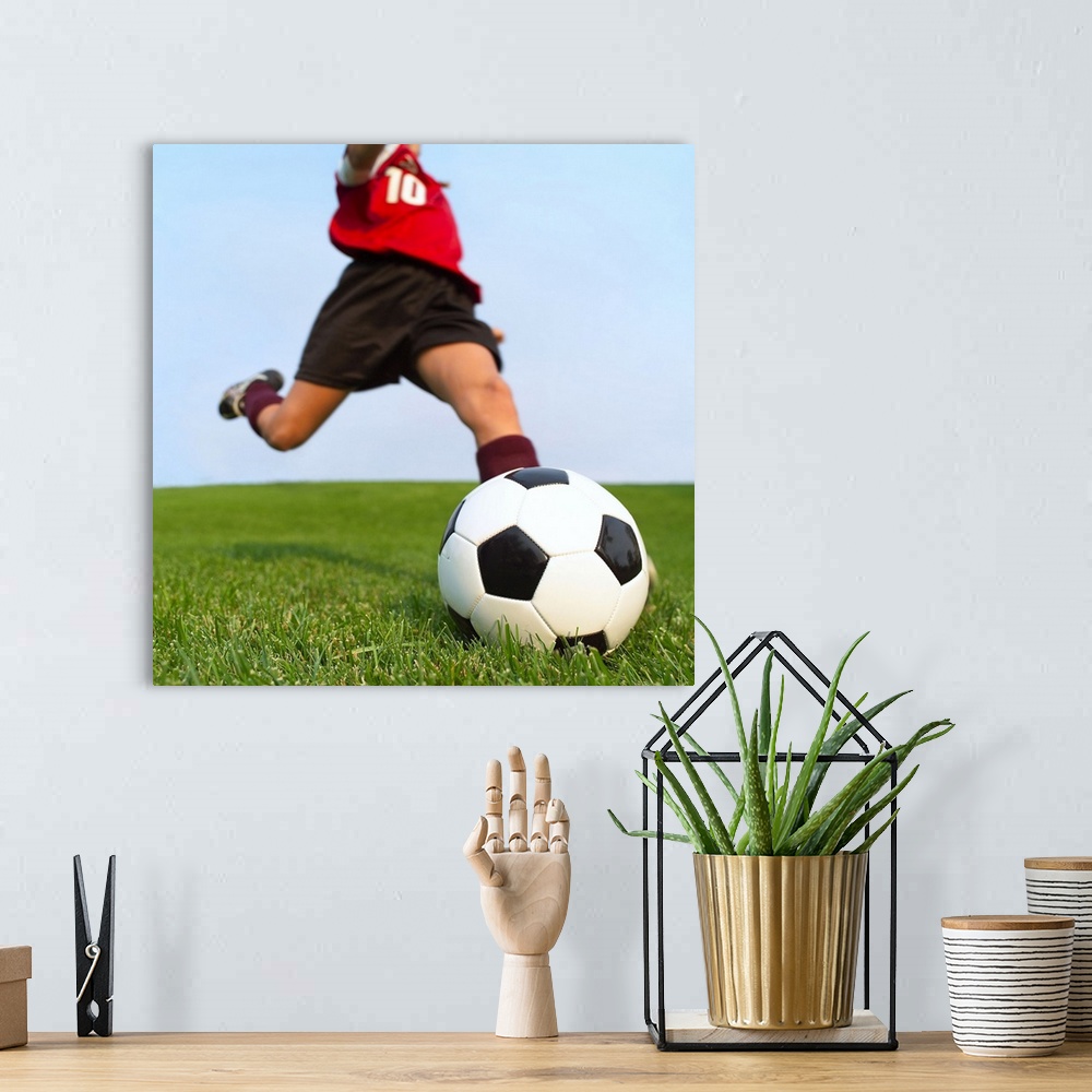 A bohemian room featuring This is a square photograph of an athlete about to kick a ball.