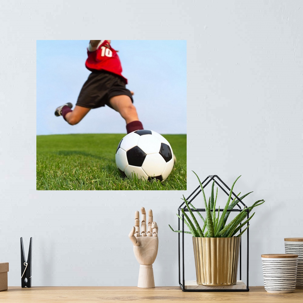 A bohemian room featuring This is a square photograph of an athlete about to kick a ball.