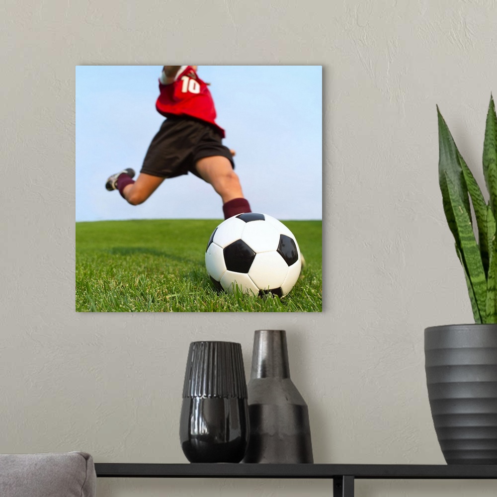 A modern room featuring This is a square photograph of an athlete about to kick a ball.