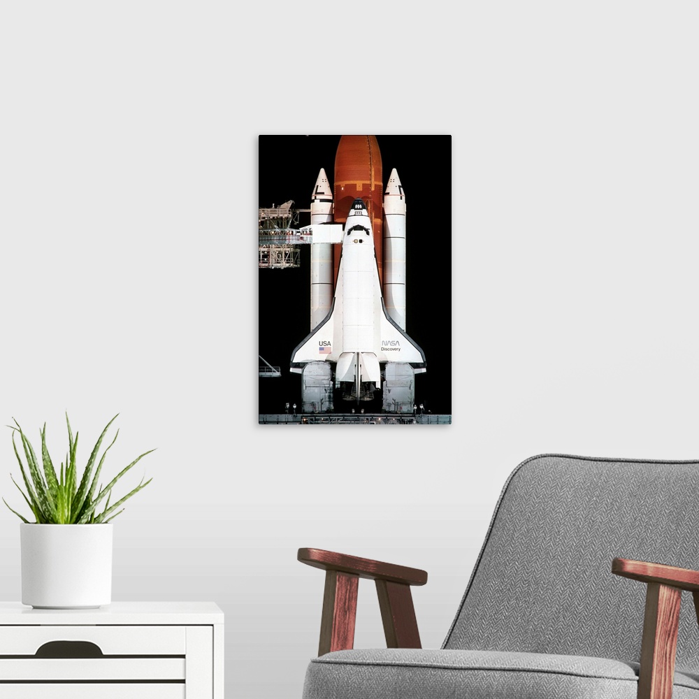 A modern room featuring The space shuttle Discovery sits on the launch pad on the eve of the launch of Space Shuttle Miss...