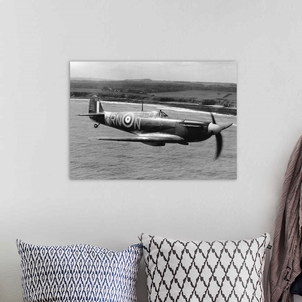 A bohemian room featuring A Spitfire in flight of the coast of Britain during World War II.
