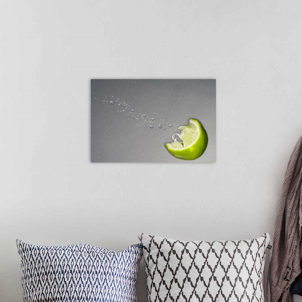 A bohemian room featuring Large canvas photo art of a lime slice with juice coming out on a neutral background.