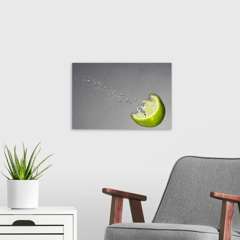 A modern room featuring Large canvas photo art of a lime slice with juice coming out on a neutral background.