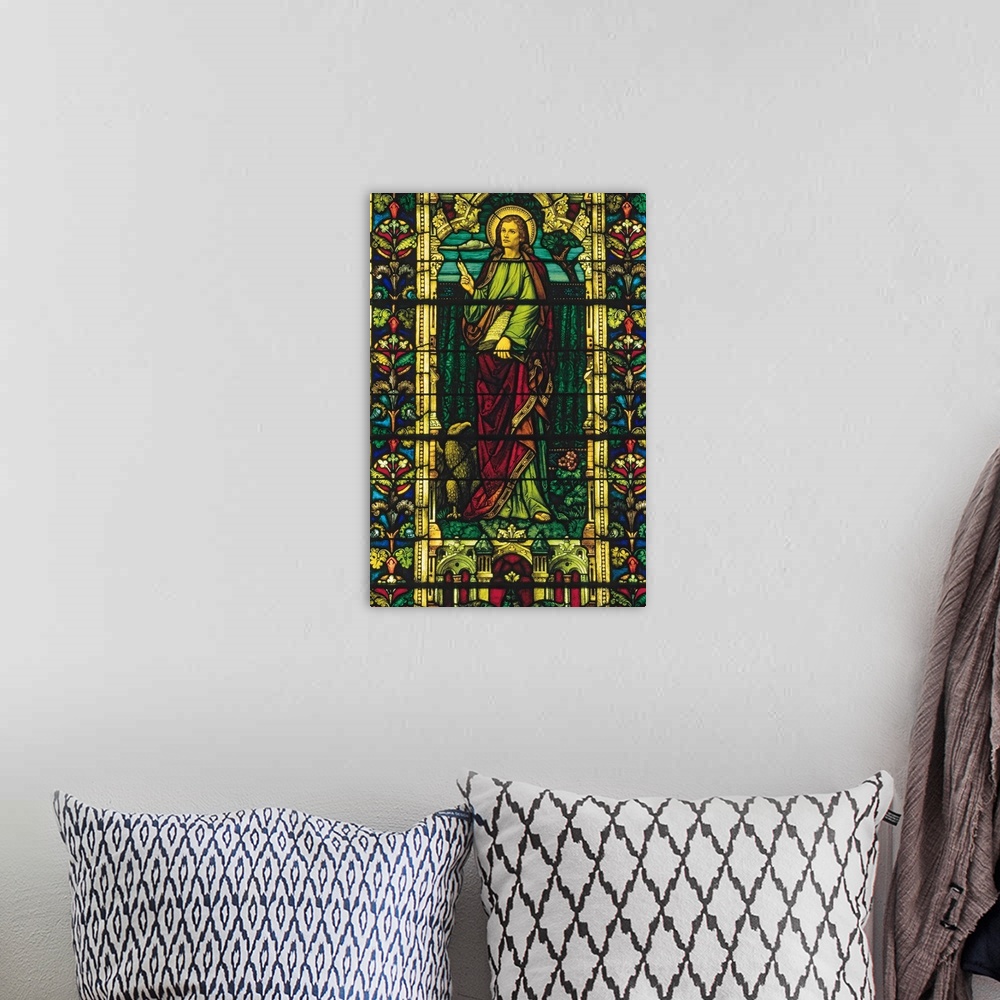 A bohemian room featuring St. John depicted in stained glass window.