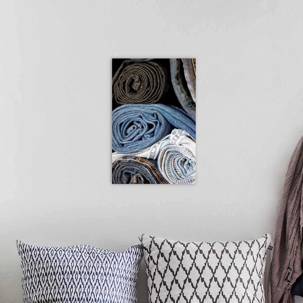 A bohemian room featuring stacked and rolled denim blue jeans of varying shades