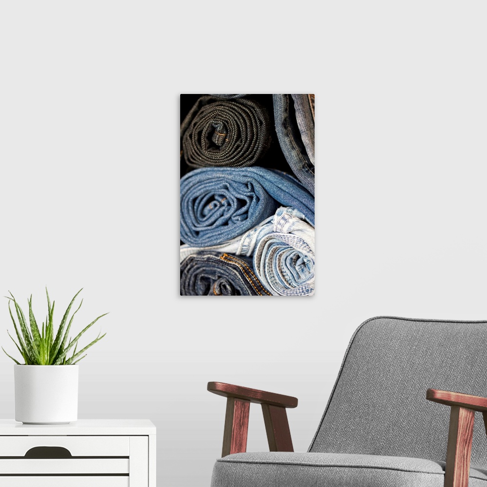 A modern room featuring stacked and rolled denim blue jeans of varying shades