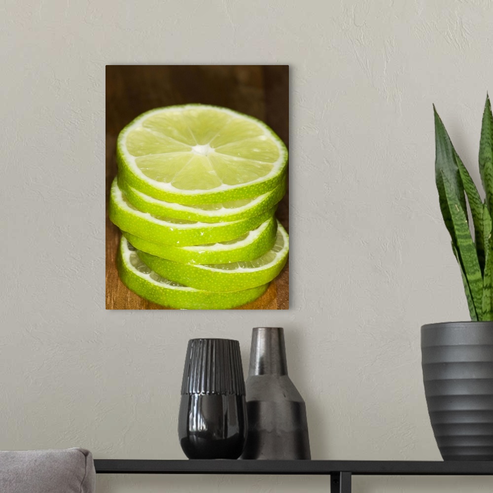 A modern room featuring stacked sliced limes on wood cutting-board