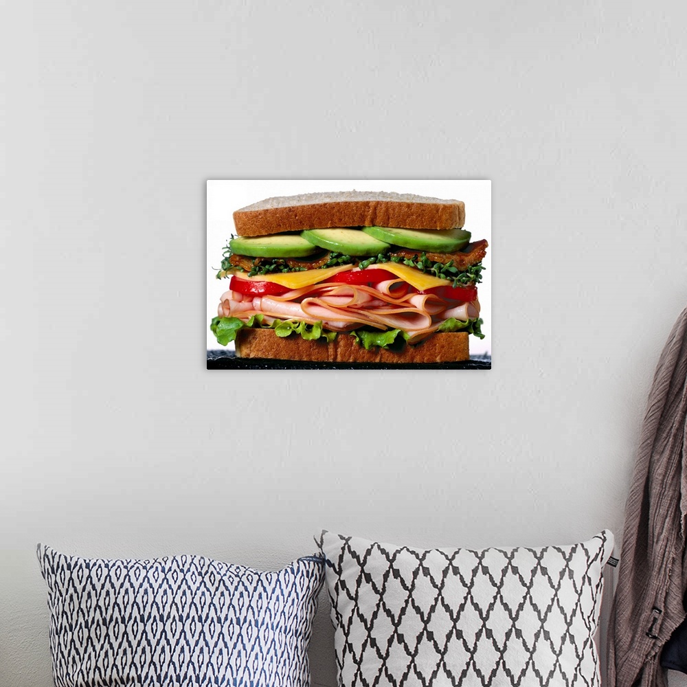 A bohemian room featuring Stacked turkey sandwich with avocados, cheese, tomatoes and crunchy lettuce