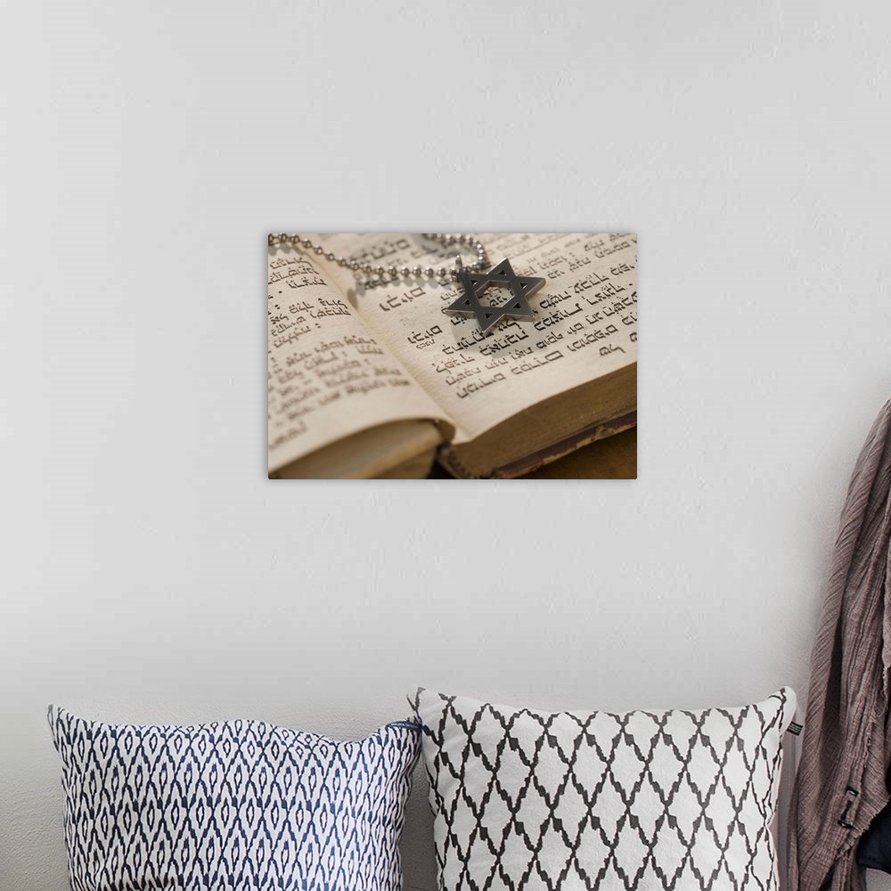 A bohemian room featuring Star of David necklace on book with Hebrew text