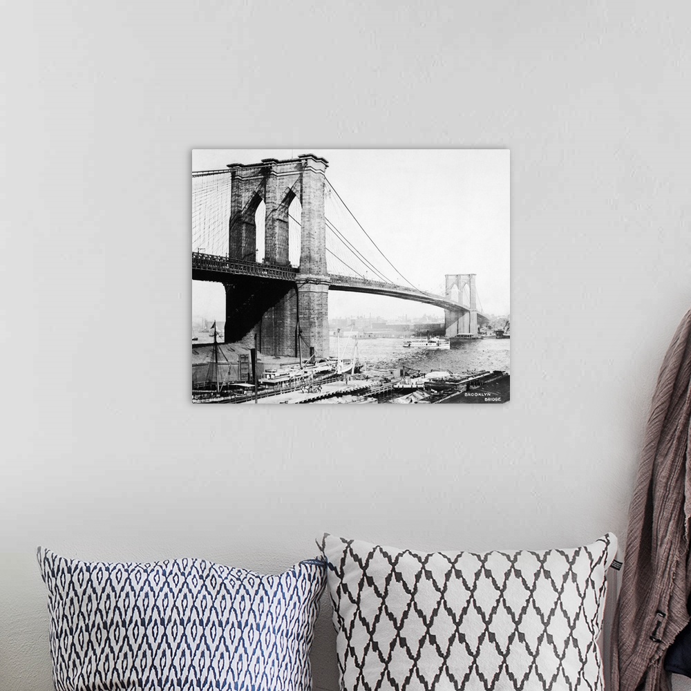 A bohemian room featuring View of the Brooklyn Bridge showing docks and boat passing underneath.