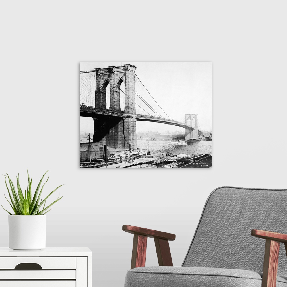 A modern room featuring View of the Brooklyn Bridge showing docks and boat passing underneath.