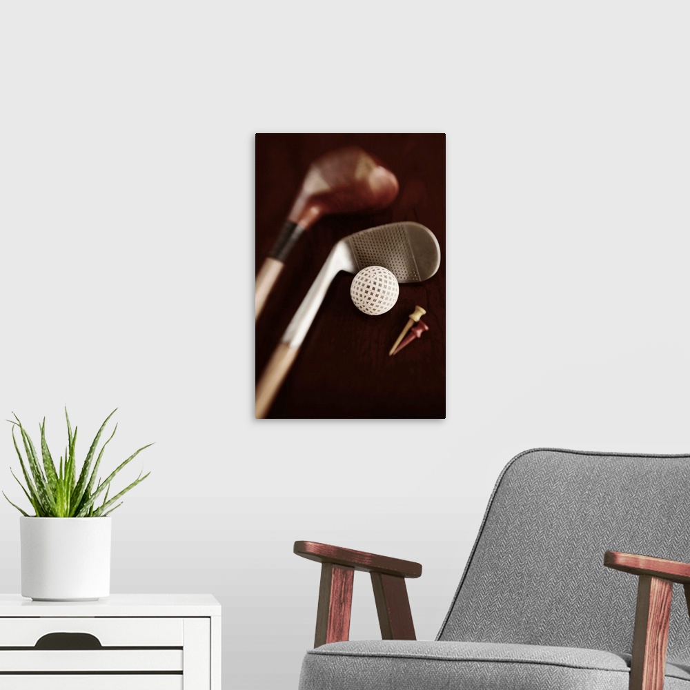 A modern room featuring Still life if vintage golf clubs, tees and ball. Selective focus on ball.