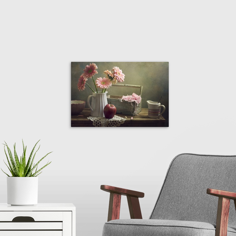 A modern room featuring Still life with pink gerberas and red apple on table.