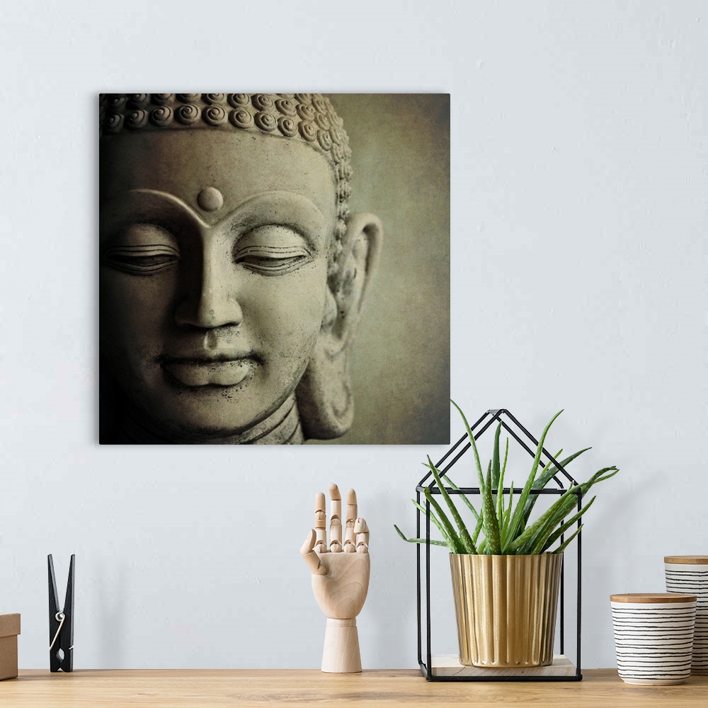 A bohemian room featuring Close up photo of the face of a  sculpture of Buddha, showing his downcast eyes and tight curls i...