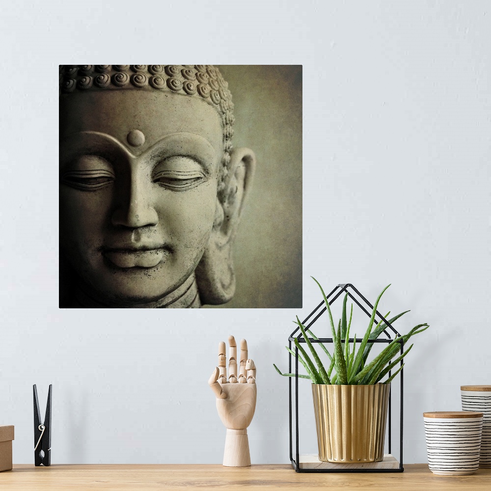 A bohemian room featuring Close up photo of the face of a  sculpture of Buddha, showing his downcast eyes and tight curls i...