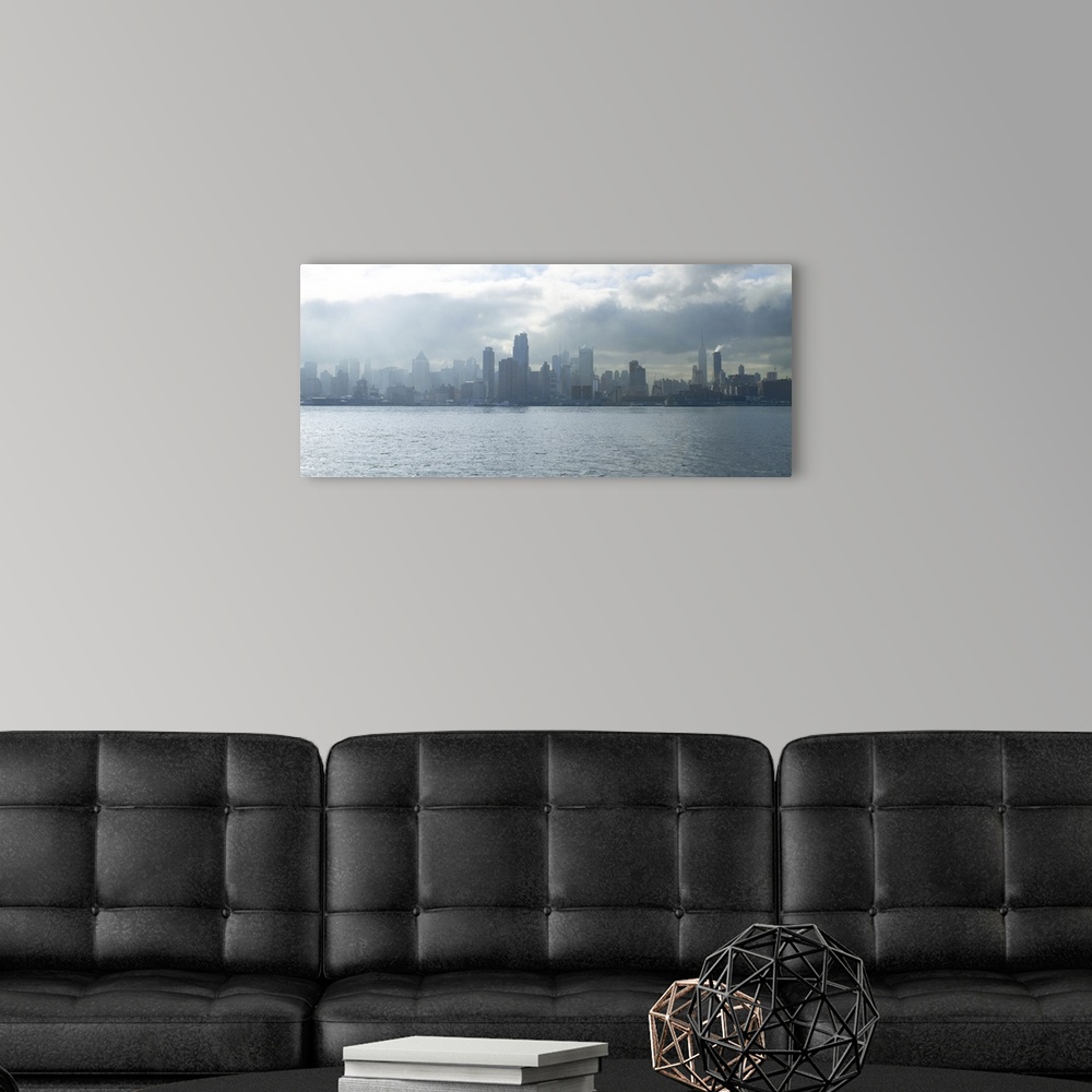 A modern room featuring Sun breaking through clouds over midtown Manhattan