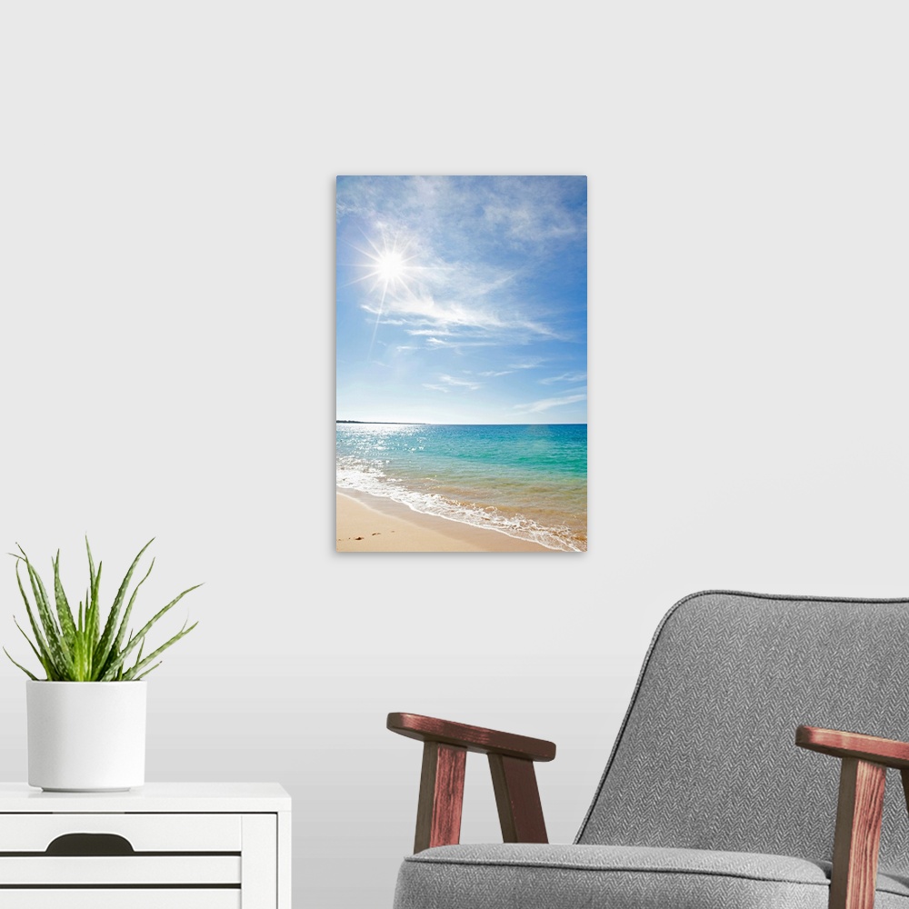 A modern room featuring Photograph of shoreline with surf rolling in under a cloudy sky.  The sun is shinning and sparkli...