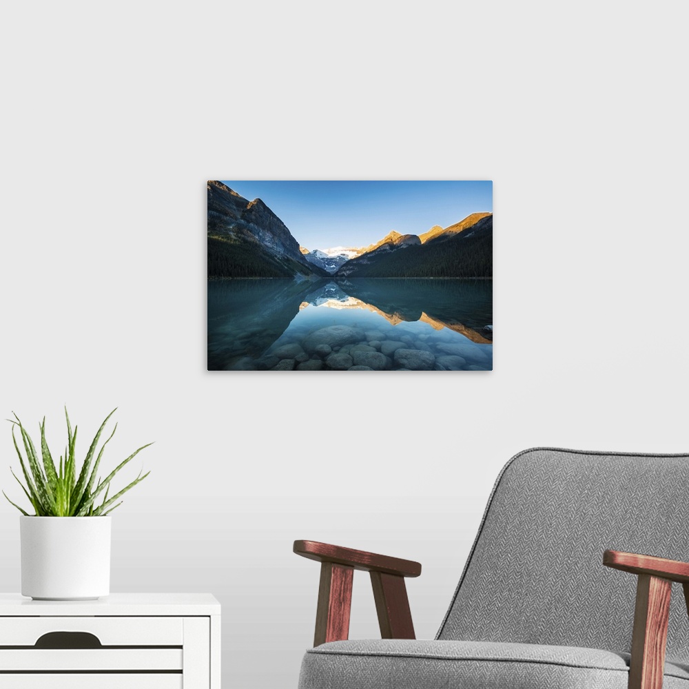 A modern room featuring Sunrise at the Lake Louis.  Sun light made mountain tops golden along with reflections on the water.