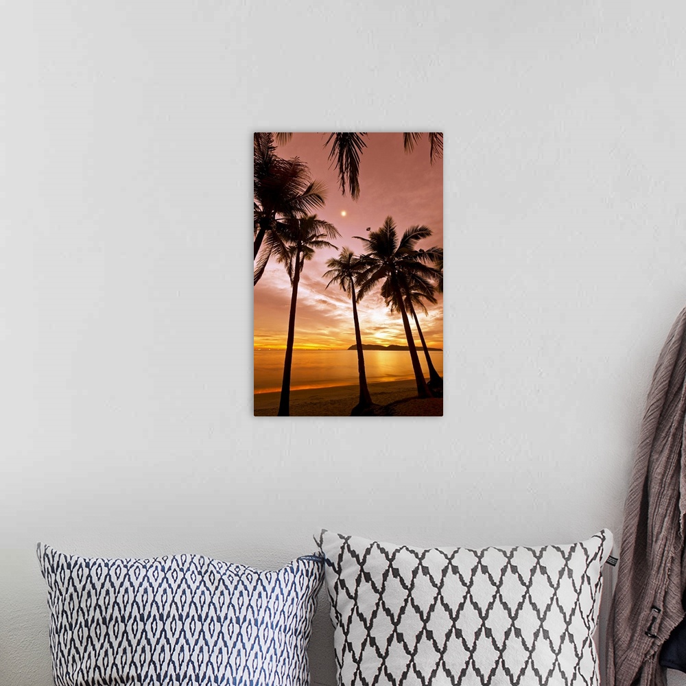 A bohemian room featuring The silhouetted of palm trees on a beach arch into the sky at sunset reaching towards the moon wh...