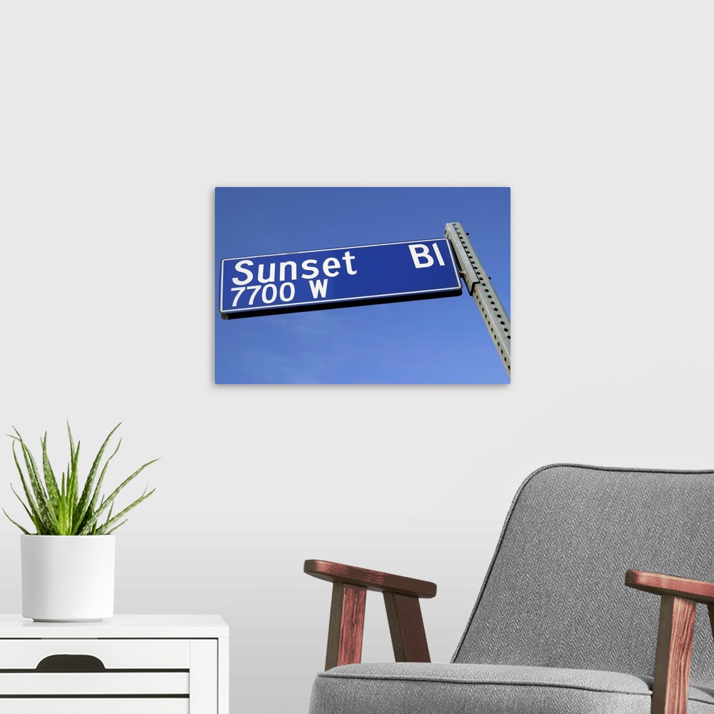 A modern room featuring Sunset Boulevard sign against a blue sky from a low angle.