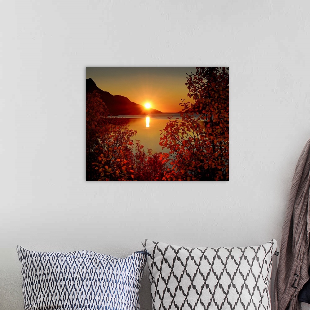 A bohemian room featuring Big photograph emphasizes the sun as it begins to set over a mountain and then reflect over a cal...