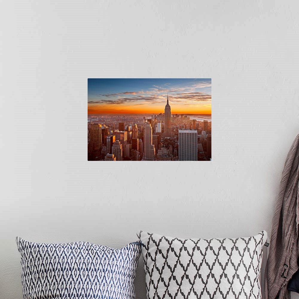A bohemian room featuring Landscape orientation photograph of skyscrapers at the end of the day.