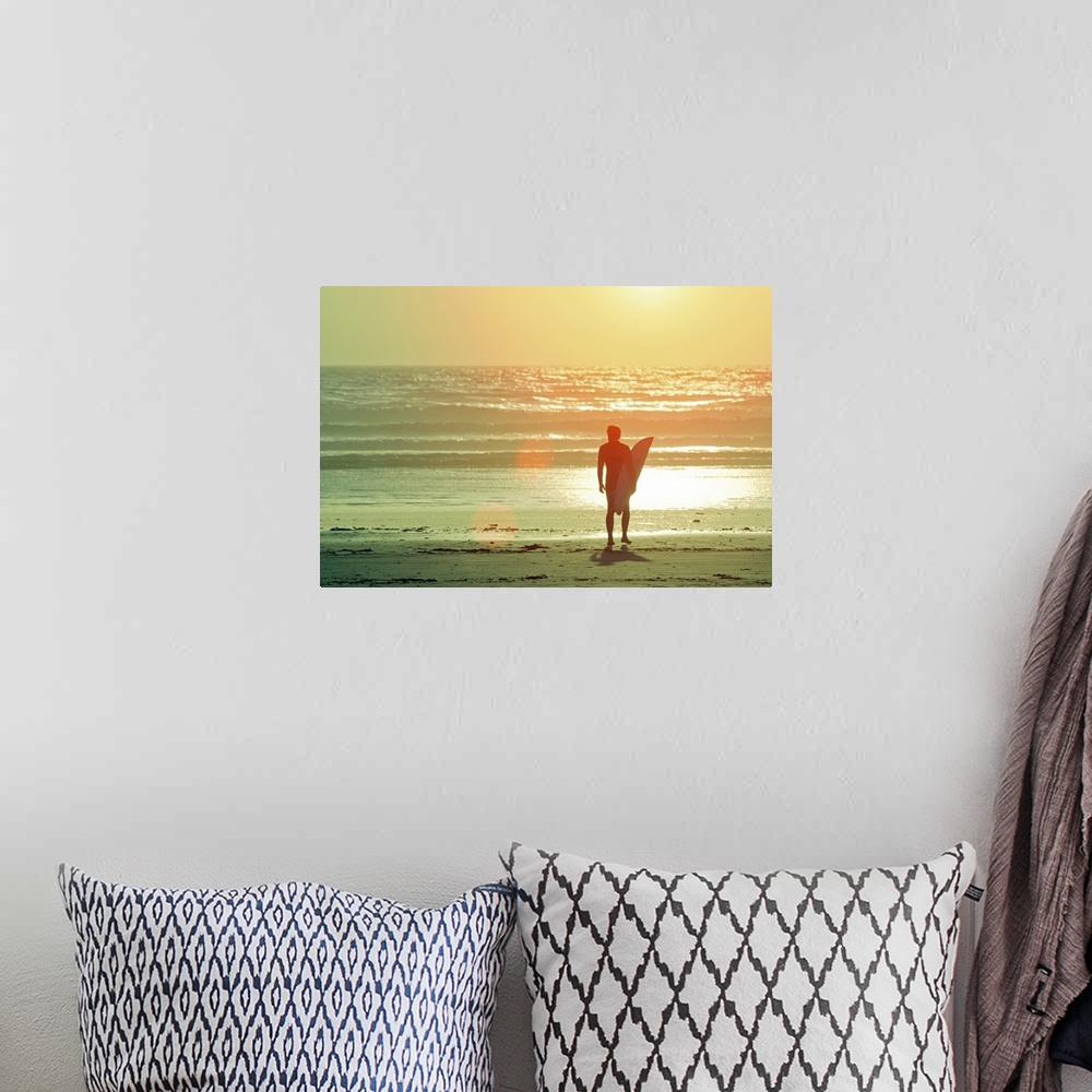 A bohemian room featuring Big print on canvas of a surfer with a surfboard silhouetted against the setting sun looking out ...