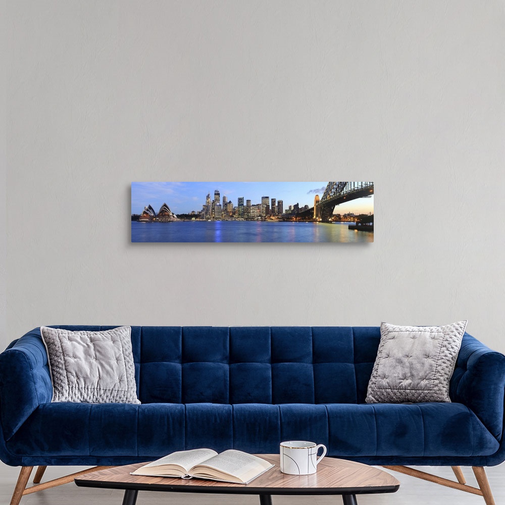 A modern room featuring Panorama of Sydney Harbour Bridge at dusk with CBD skyline and the Opera House.