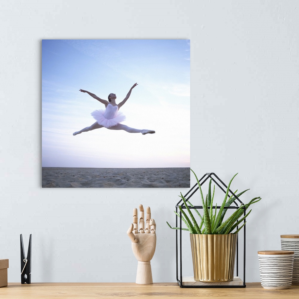 A bohemian room featuring Teenage ballerina (16-18) performing leap on beach, low angle view