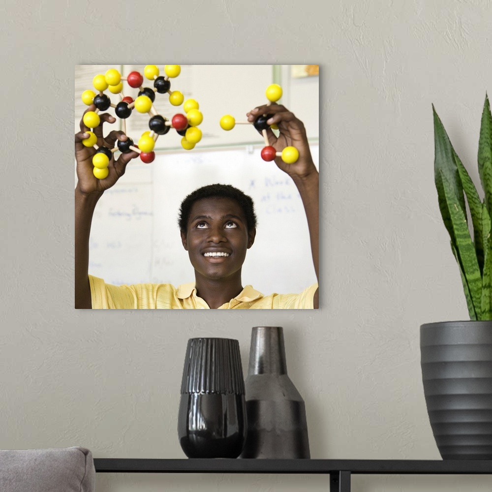 A modern room featuring African teenage boy viewing molecule model