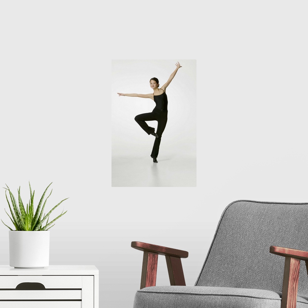 A modern room featuring Teenage girl (14-15) performing gymnastic in studio, portrait