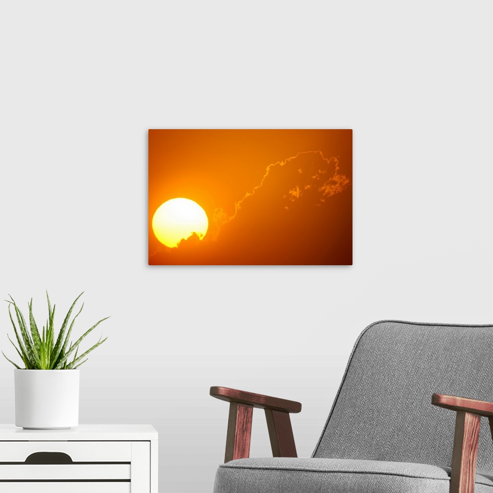 A modern room featuring Telephoto view of the rising sun behind orange clouds, Durban, Kwazulu-Natal, South Africa