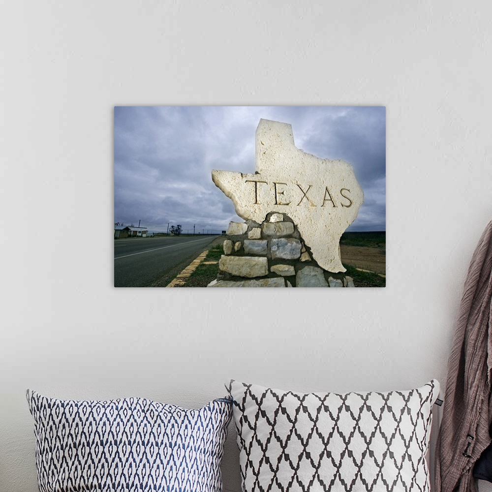 A bohemian room featuring Photograph of a large stone placard in the shape of Texas welcoming visitors at the state border.