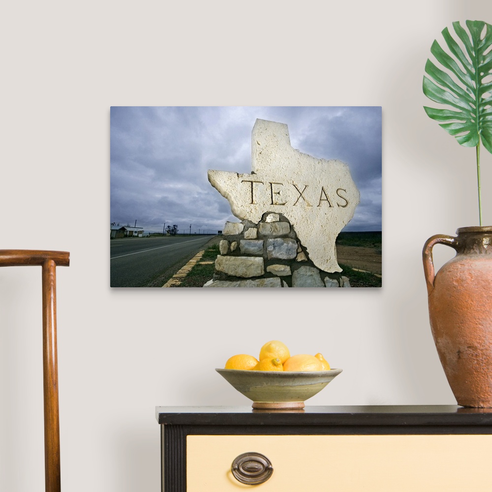 A traditional room featuring Photograph of a large stone placard in the shape of Texas welcoming visitors at the state border.