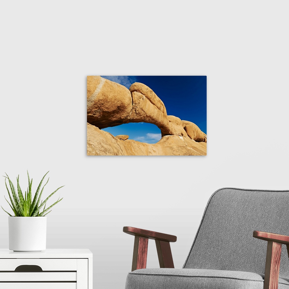 A modern room featuring the arch at Spitzkoppe or Spitzkuppe, arid mountain landscape of granite rocks, Matterhorn of Nam...