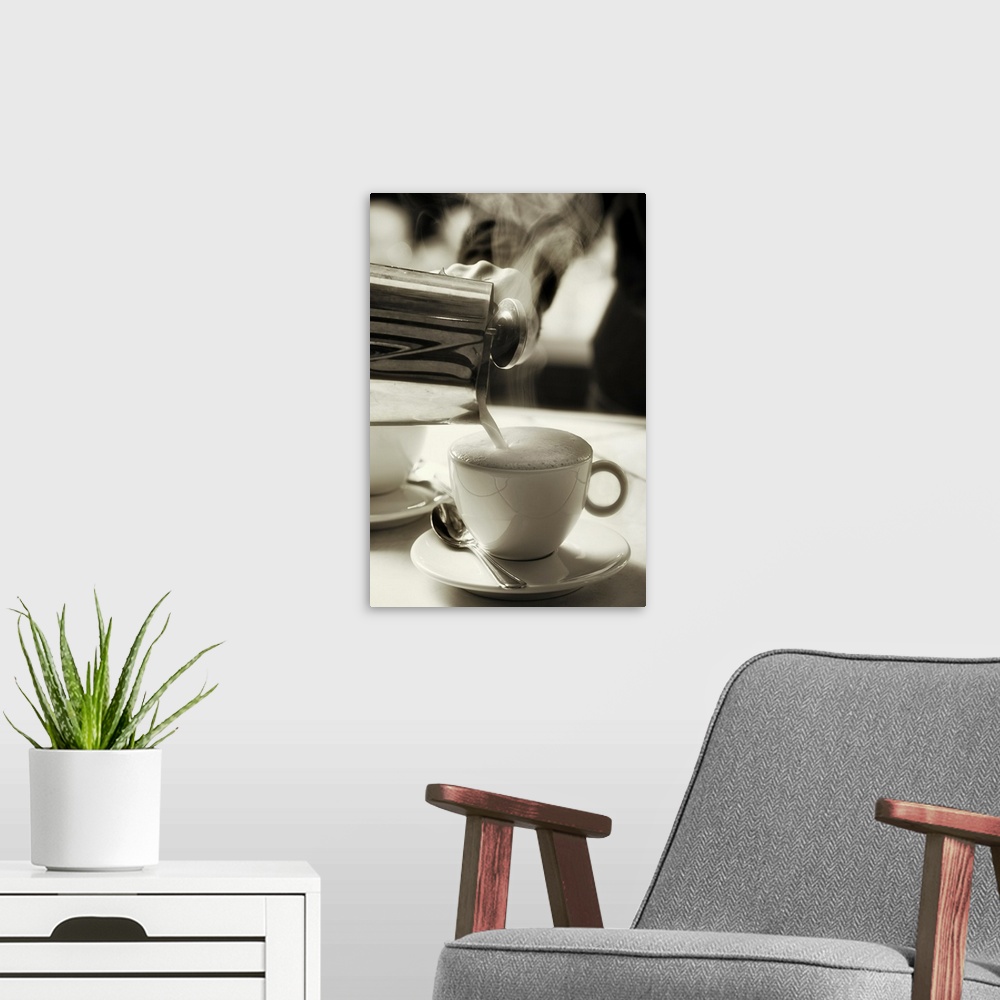A modern room featuring The art of fresh coffee making / adding steamed milk to make a cappuccino