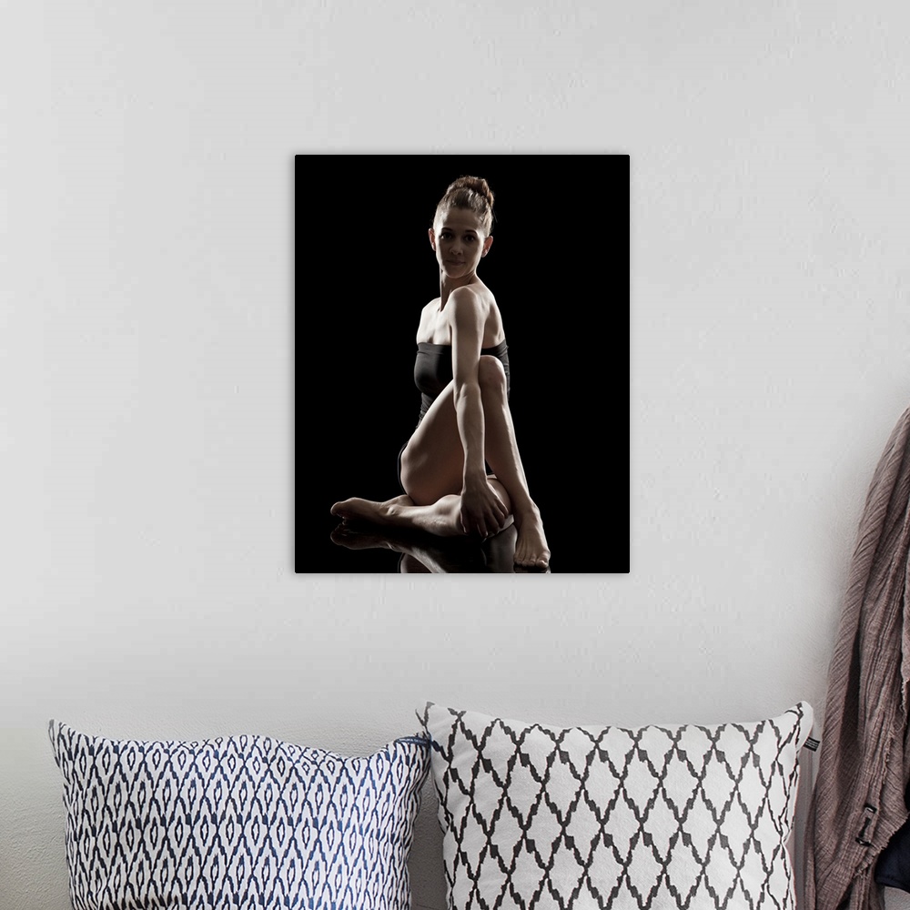 A bohemian room featuring Studio shot of young woman practicing yoga.  The half spinal twist pose, ardha matsyendra asana