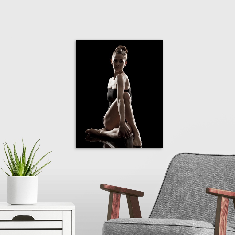 A modern room featuring Studio shot of young woman practicing yoga.  The half spinal twist pose, ardha matsyendra asana