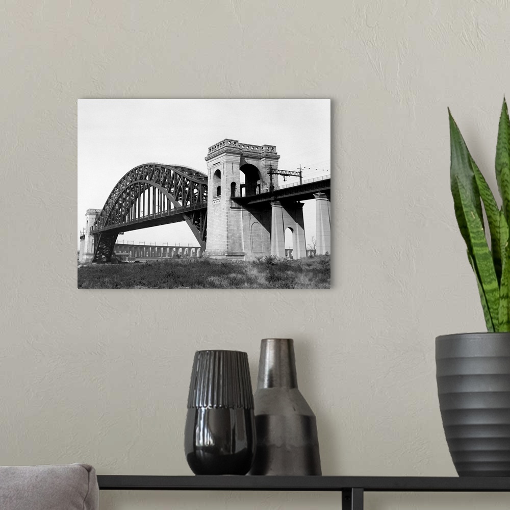 A modern room featuring The Hell Gate Bridge links Queens with the Bronx over a channel separating Astoria and Ward's Isl...