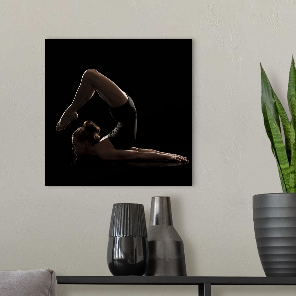 A modern room featuring Studio shot of young woman practicing yoga.  The scorpion pose, vrshikasana