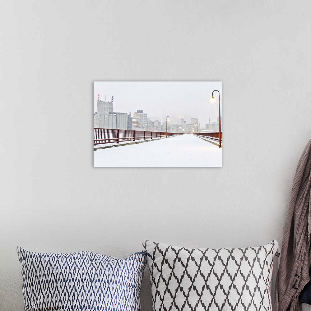 A bohemian room featuring The Stone Arch Bridge in Minneapolis Minnesota during winter with snow on it.