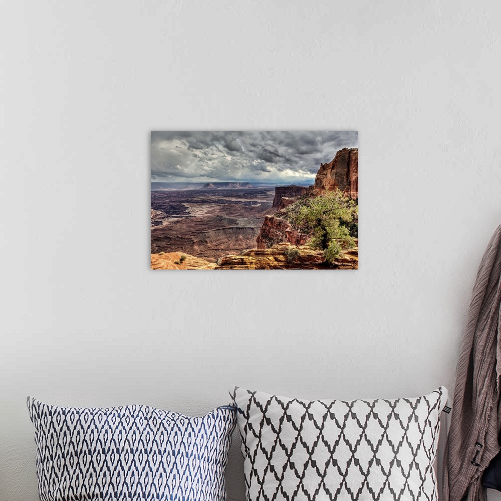 A bohemian room featuring A view near Mesa Arch into the vast Canyonlands National Park during a stormy day.  A rare rain s...