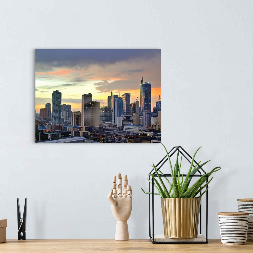 A bohemian room featuring The sun setting light up low clouds over the Makati City, Manila Skyline. Many Tall buildings and...