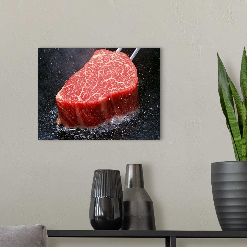 A modern room featuring Thick steak cooking in a hot oiled pan