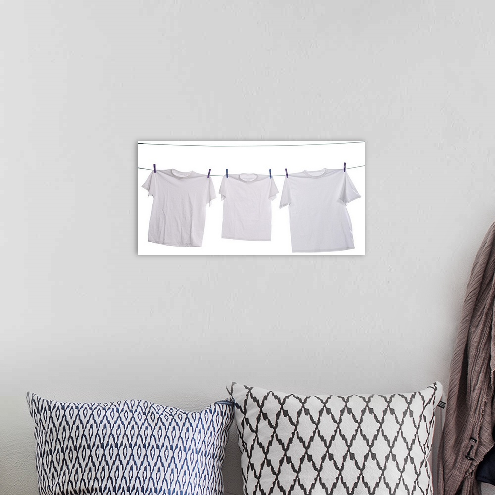 A bohemian room featuring Three white shirts drying on the clothesline
