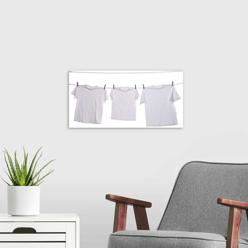 A modern room featuring Three white shirts drying on the clothesline